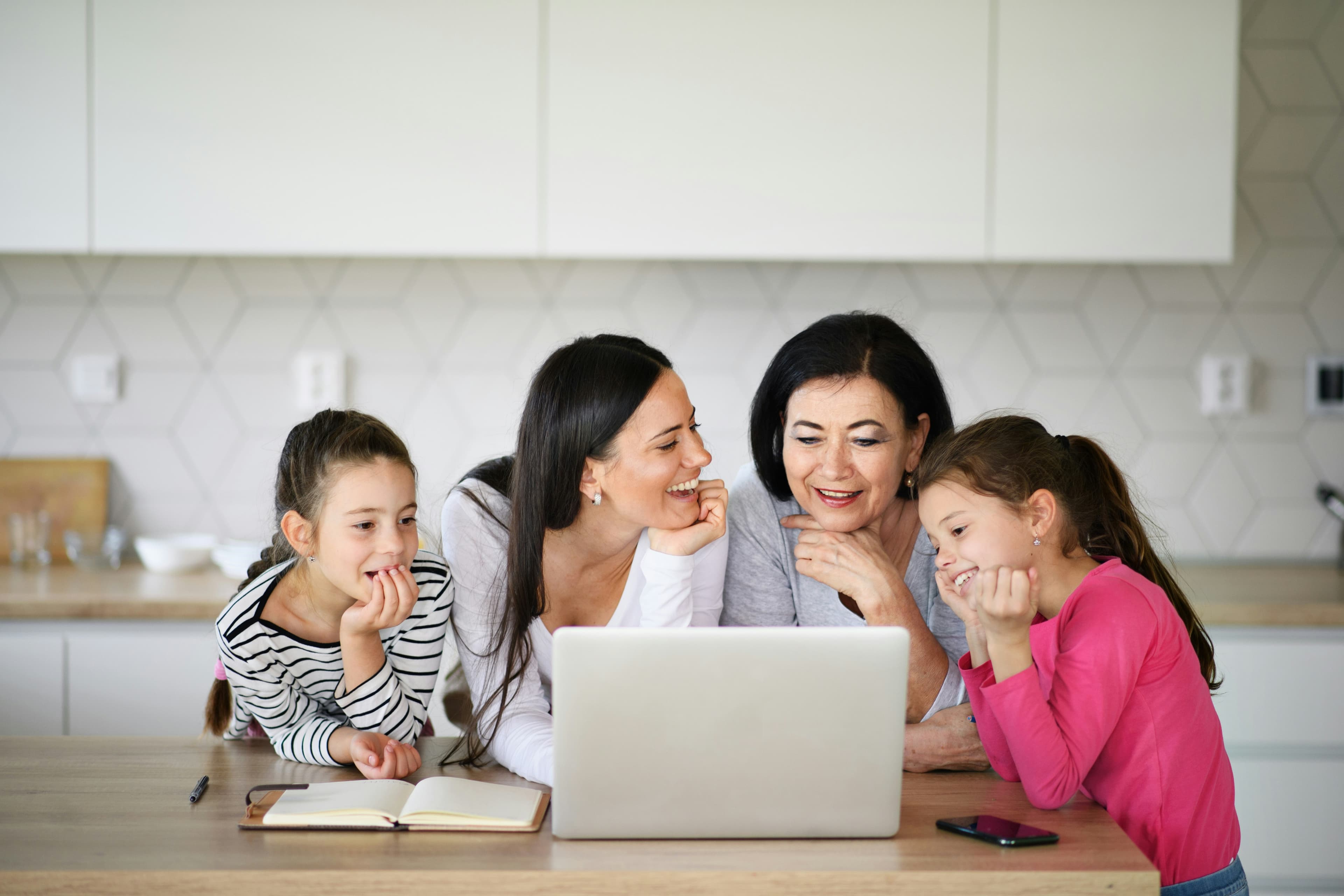 A happy family sitting around a laptop, symbolizing shared online experiences and the need for secure email.